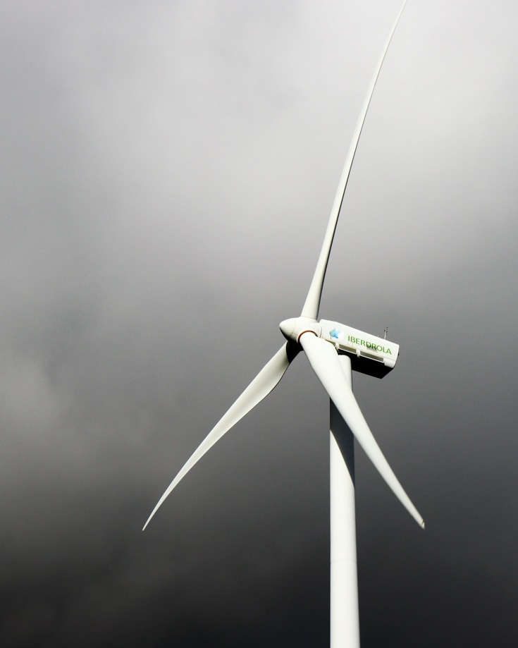 A wind turbine against a cloudy grey sky