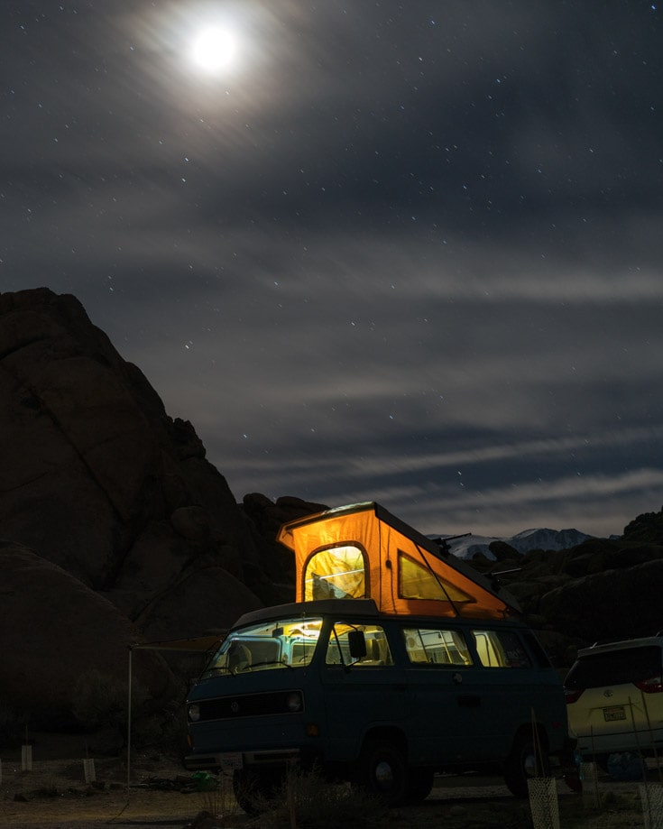 A camper van keeping a low profile under a full moon