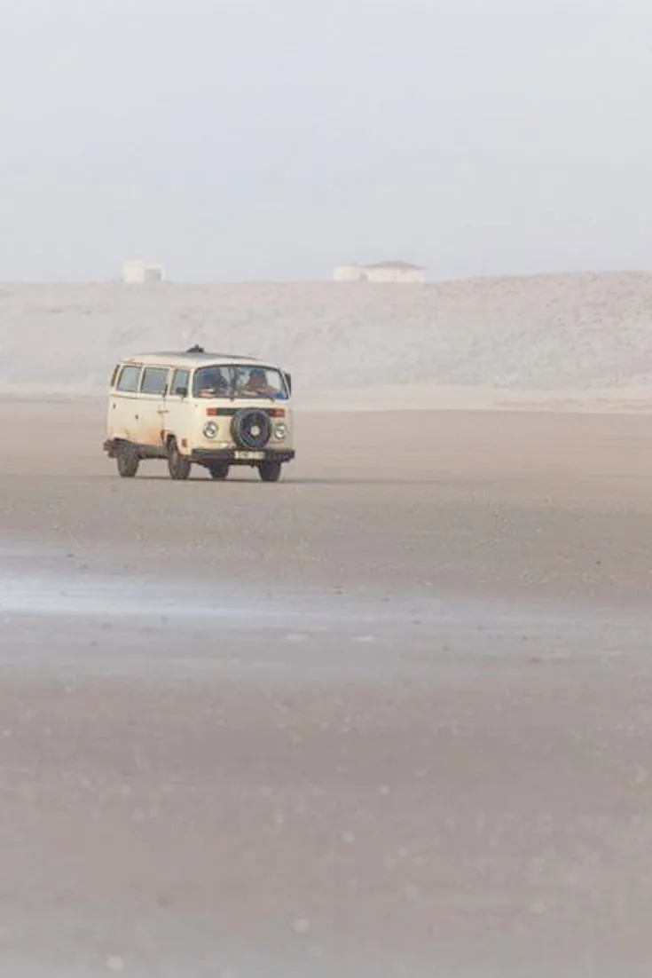 Old VW campervan driving on the beach in Morocco