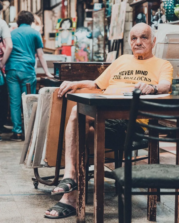 A man sitting at a table watching the world go by in San Telmo market