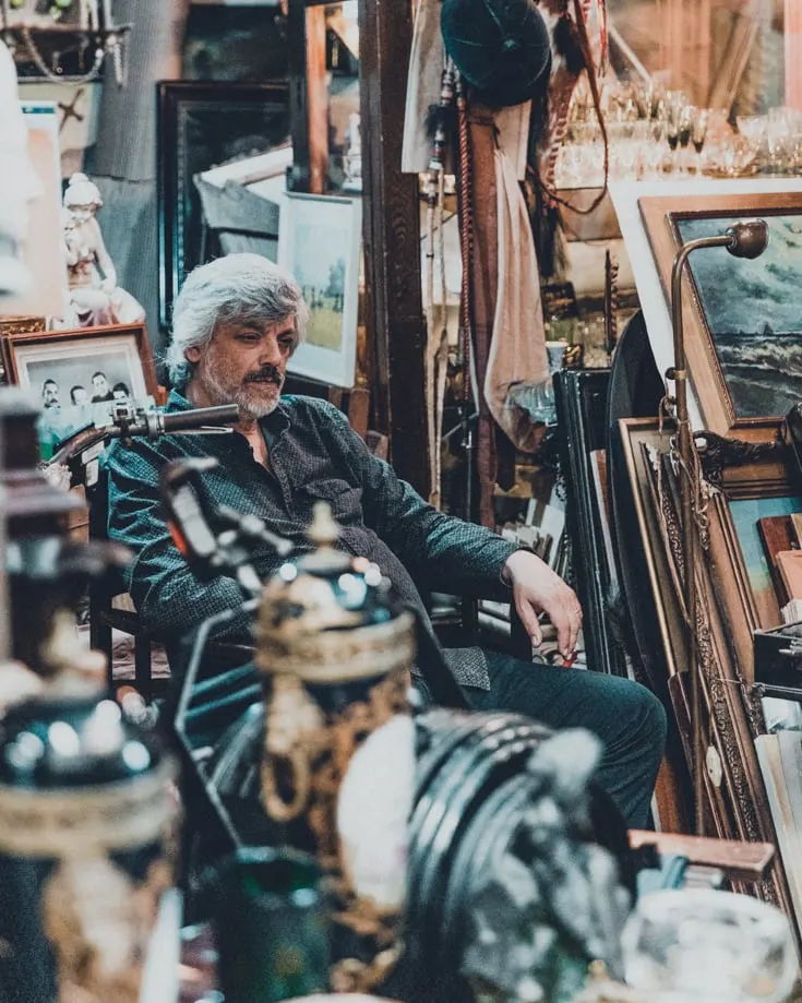 An antiques stall owner waiting for customers in Mercado de San Telmo