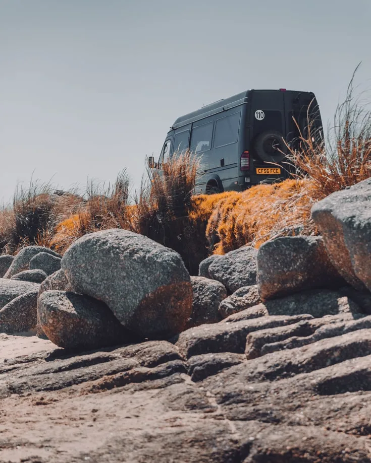 Sprinter camper van free camping on a rocky outcrop in Punta del Diablo Uruguay
 