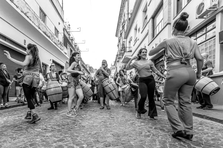 dancers leading a Candombe tripue through cobbled streets