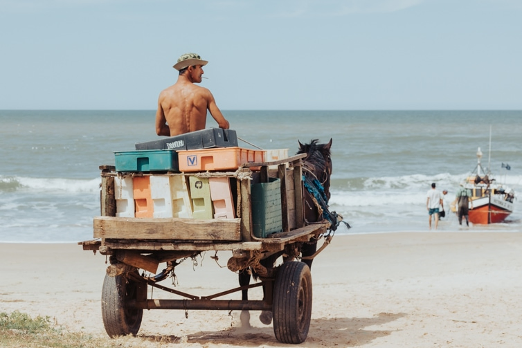 horse drawn cart arrive at Playa del los Pescadores, the driver smoking a cigarette.