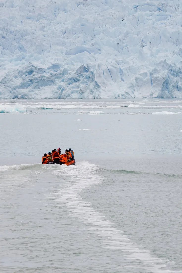 Zodiac with passengers sailing towards the blue face of San Rafael Glacier