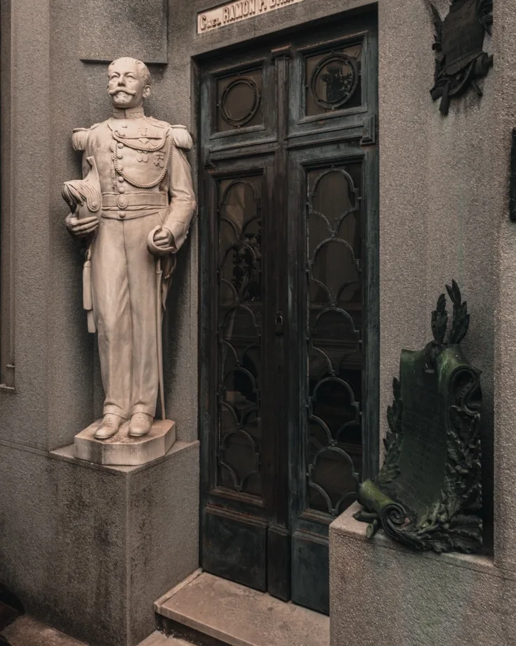 A statue of someone on a mausoleum in La Recoleta Cemetery Buenos Aires