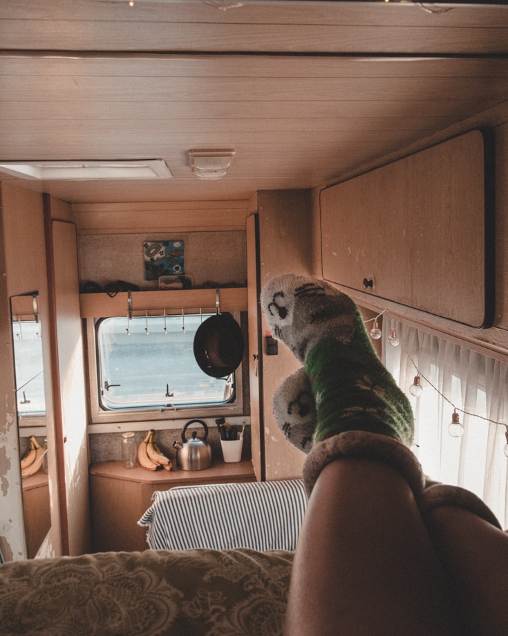 feet and legs sticking out of a campervan bed