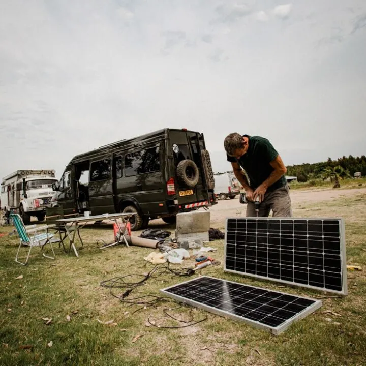 A man fitting solar panels to a Sprinter campervan conversion