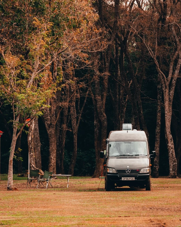 DIY camper van conversion parked in a forest