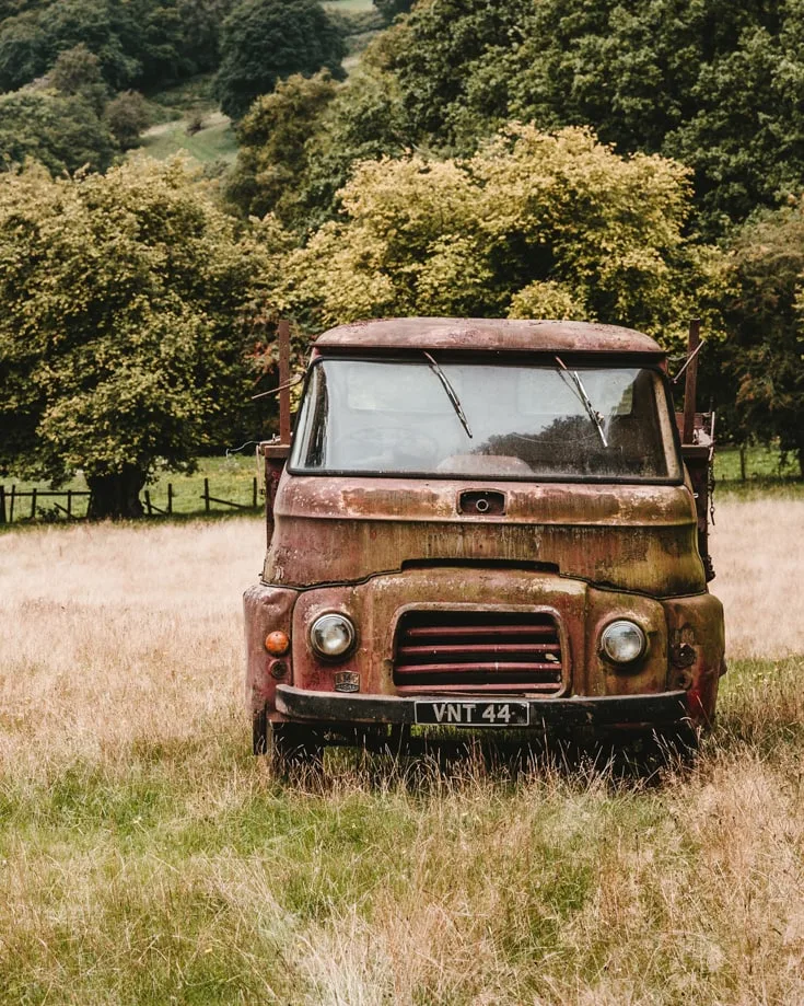 Old rusty campervan abandoned in a grassy field 