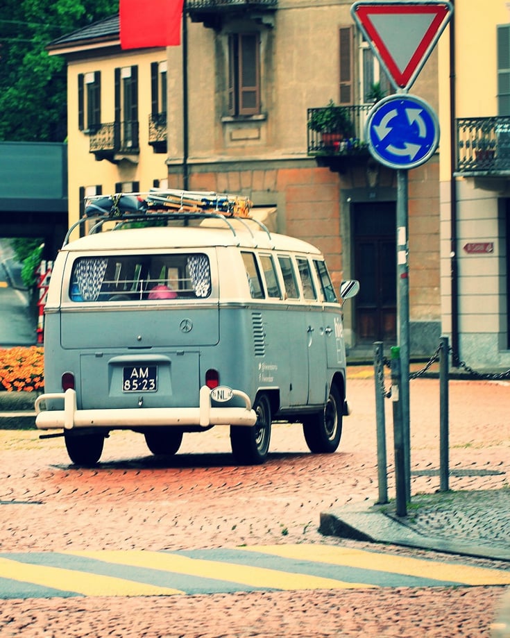 A VW campervan driving through a town
