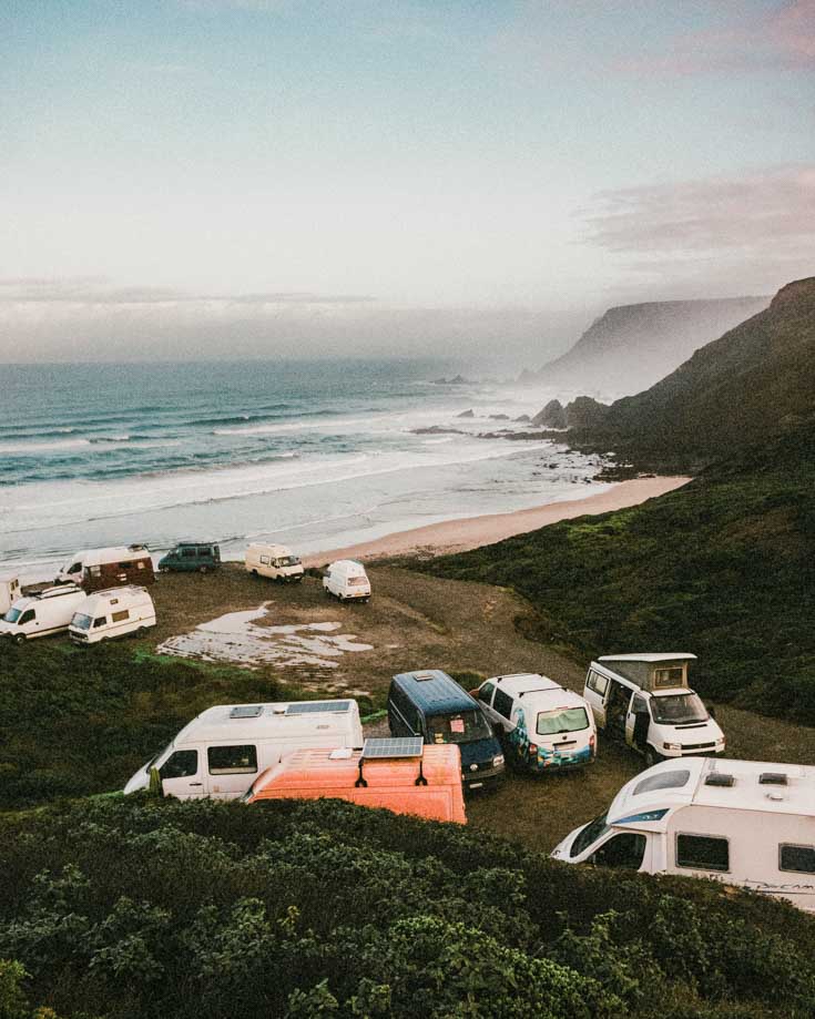 Several campers parked on the coast, some with solar panels