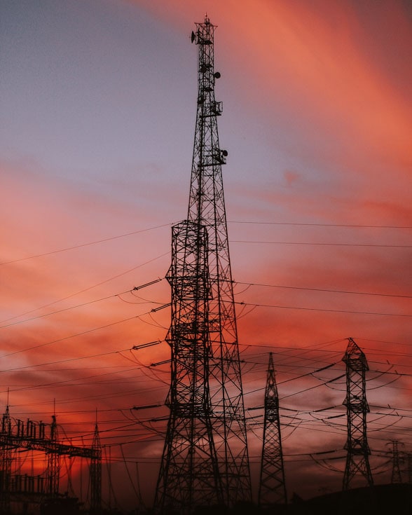 electricty pylons against a sunset sky of pinks and blues