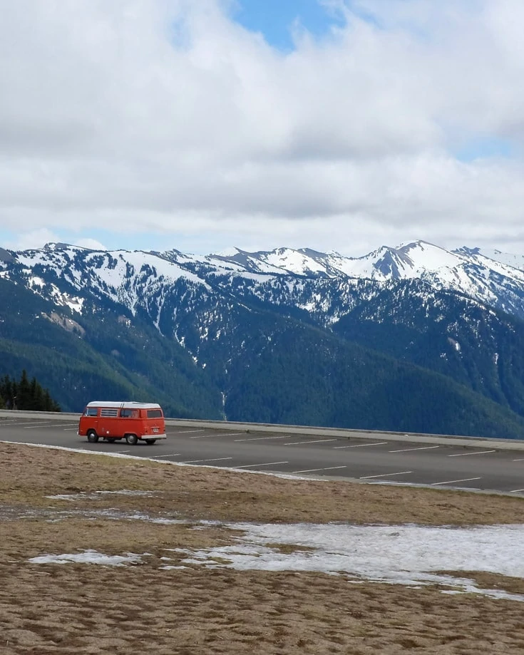 red campervandriving through a wintery mountain scene