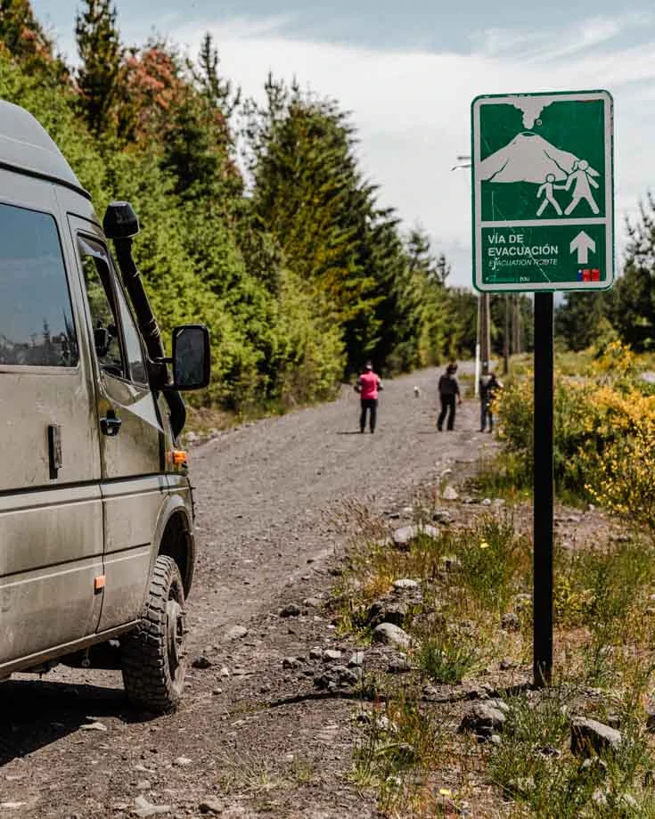 Mercedes Sprinter 4x4 camper van driving beside a Volcano warning sign