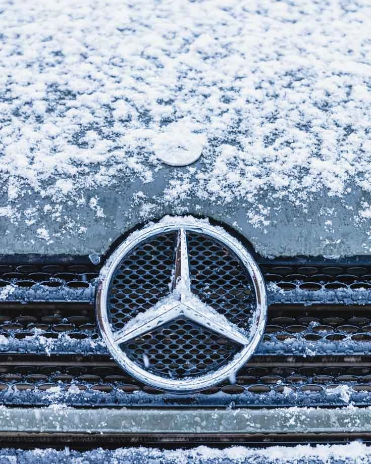 Close up of Mercedes Sprinter campervan badge snow covered