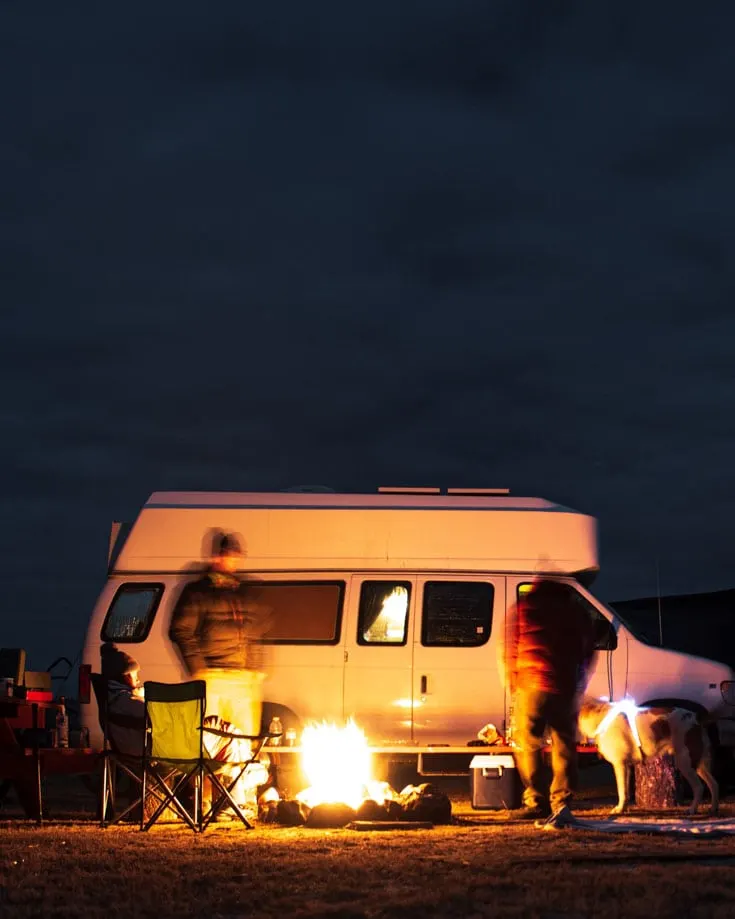 campfire beside a campervan at night