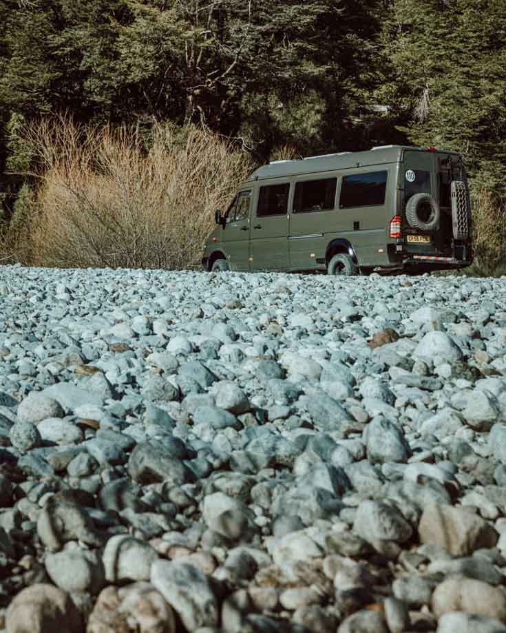 DIY Campervan conversion x4x camper parked on a pebble beach