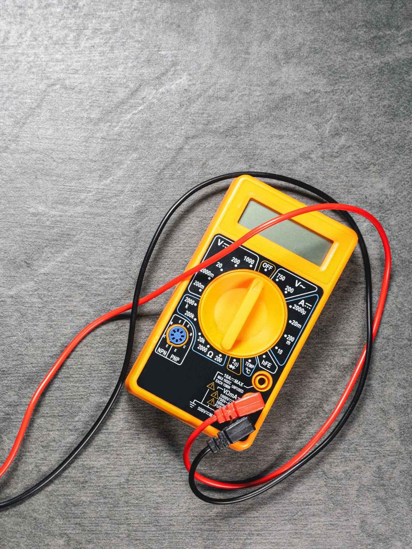 A brightly coloured multimeter with probes