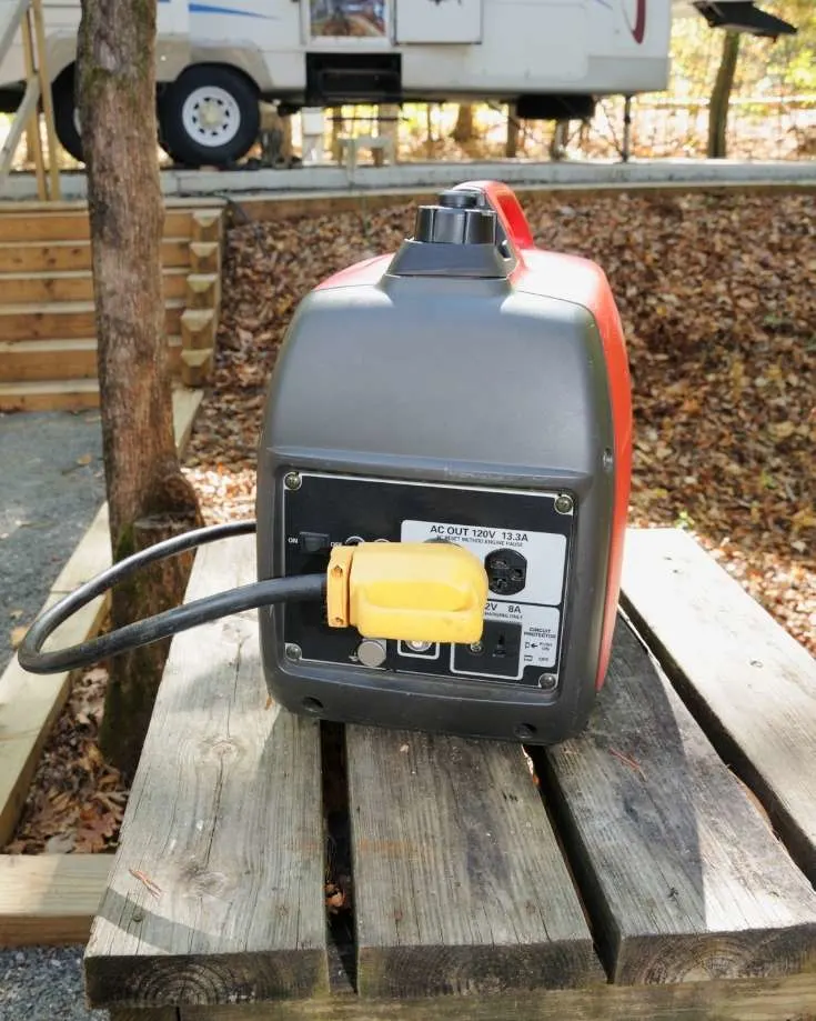 portable inverter generators on a camp table beside an RV