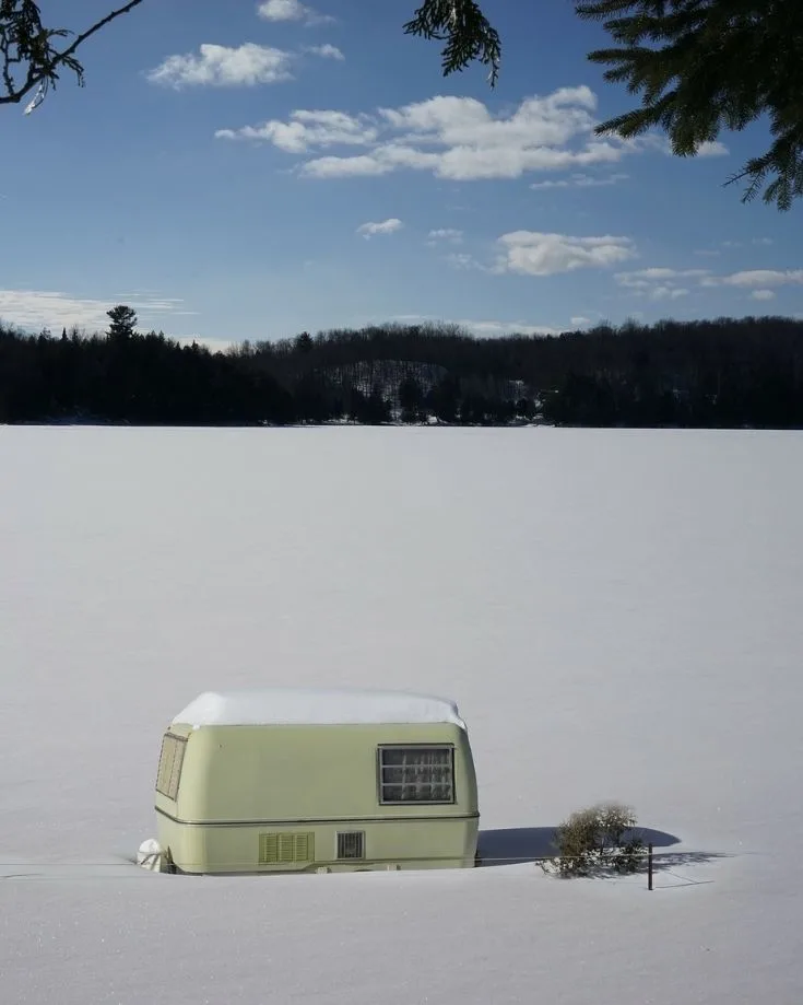 travel trailer camping in the winter, surrounded by deep snow