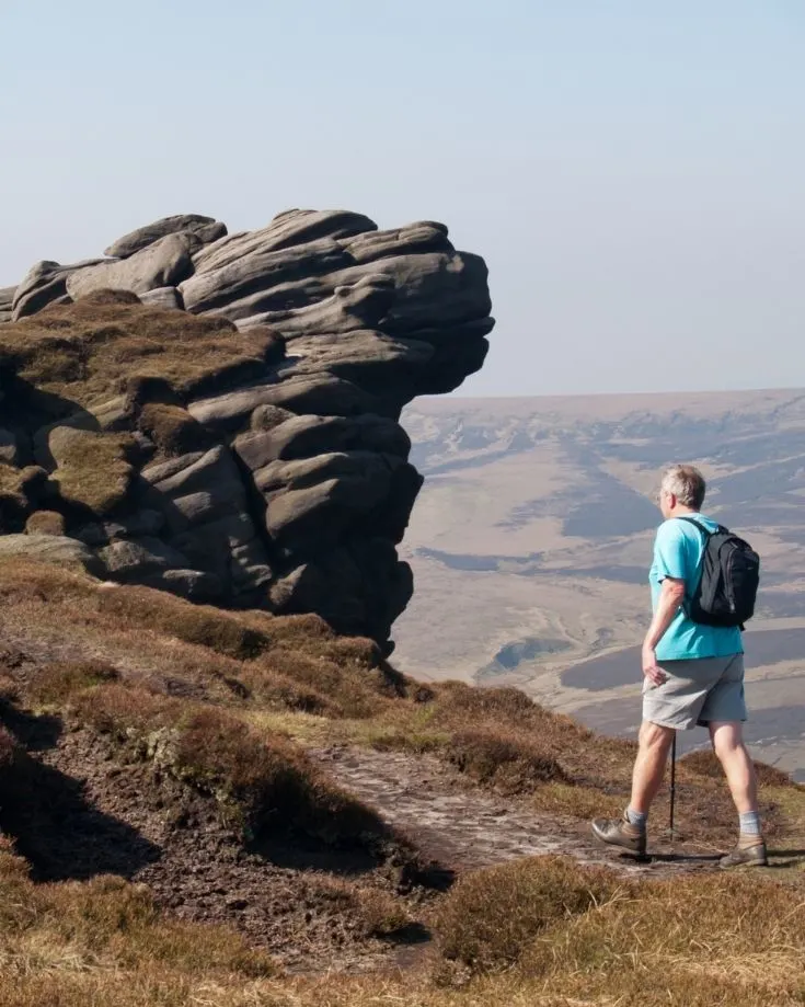 Hiker reaching the summit of Kinder Scout