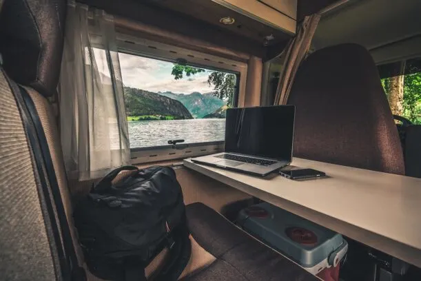 working on computer earning money traveling in a van