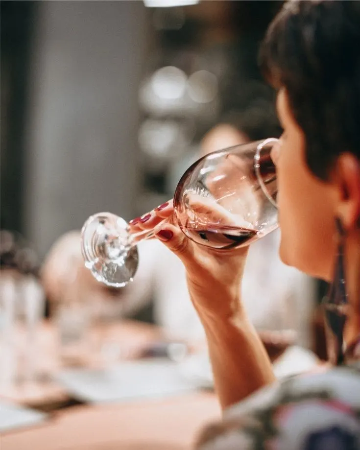 A woman tasting a glass of malbec on a wine tasting tour