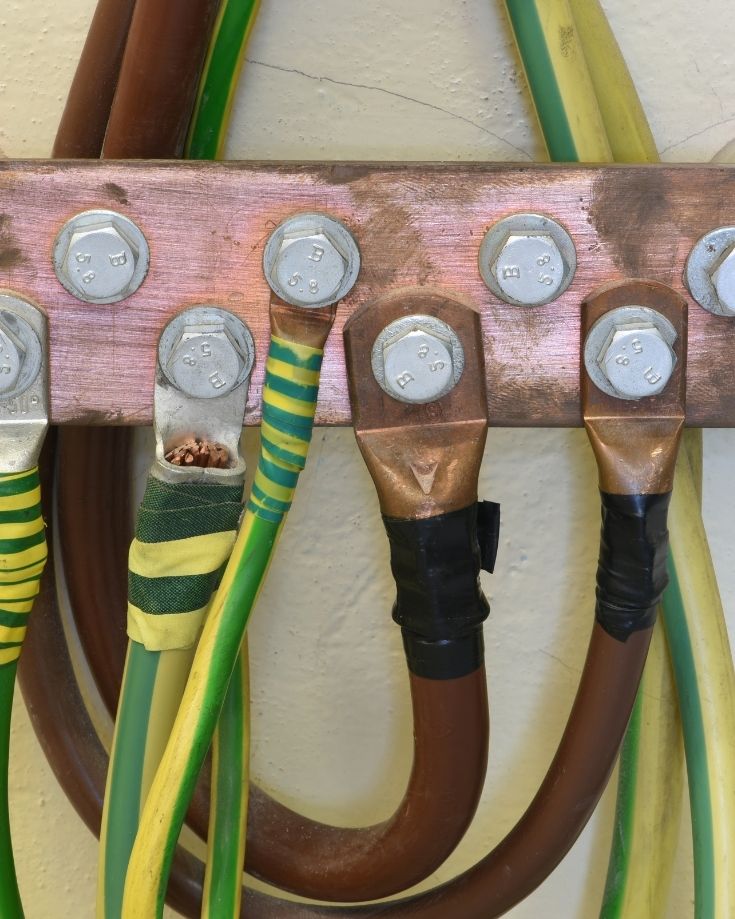 close up of a copper busbar and studs with connected cables