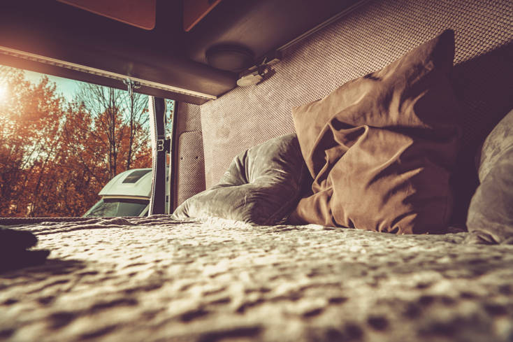 Camper Van Motorhome Comfortable Bed with the Outdoor View.