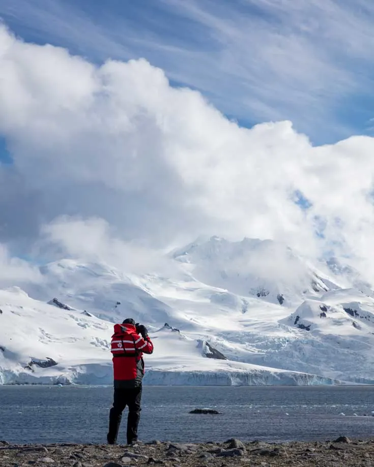 A person stood on Antarctica watching the landscape through binoculars
