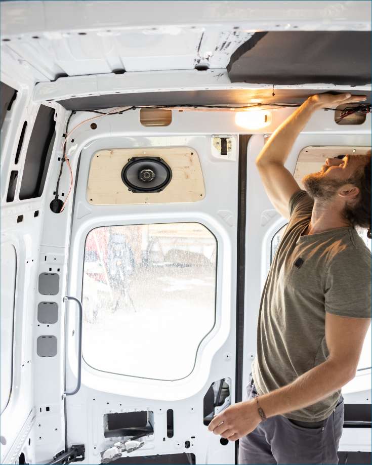 man applying insulation to a van