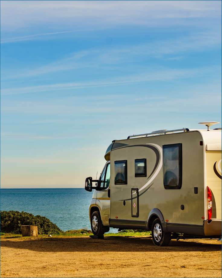 An RV parked on uneven terrain, leveled perfectly with hydraulic jacks